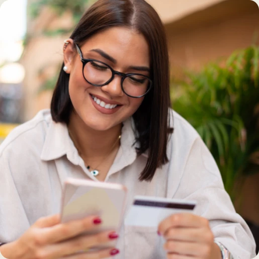 Eine Frau hält ein Smartphone und eine Kreditkarte