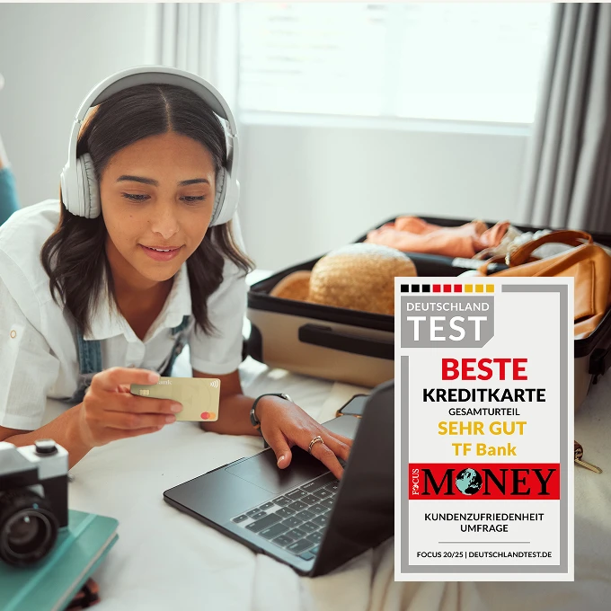 Mädchen liegt auf Bett mit Kopfhörern auf. Vor ihr liegt ein Laptop und sie hat die TF Mastercard Gold in der Hand. Auf dem Bett liegt außerdem bereit ein Koffer und ein Fernglas.