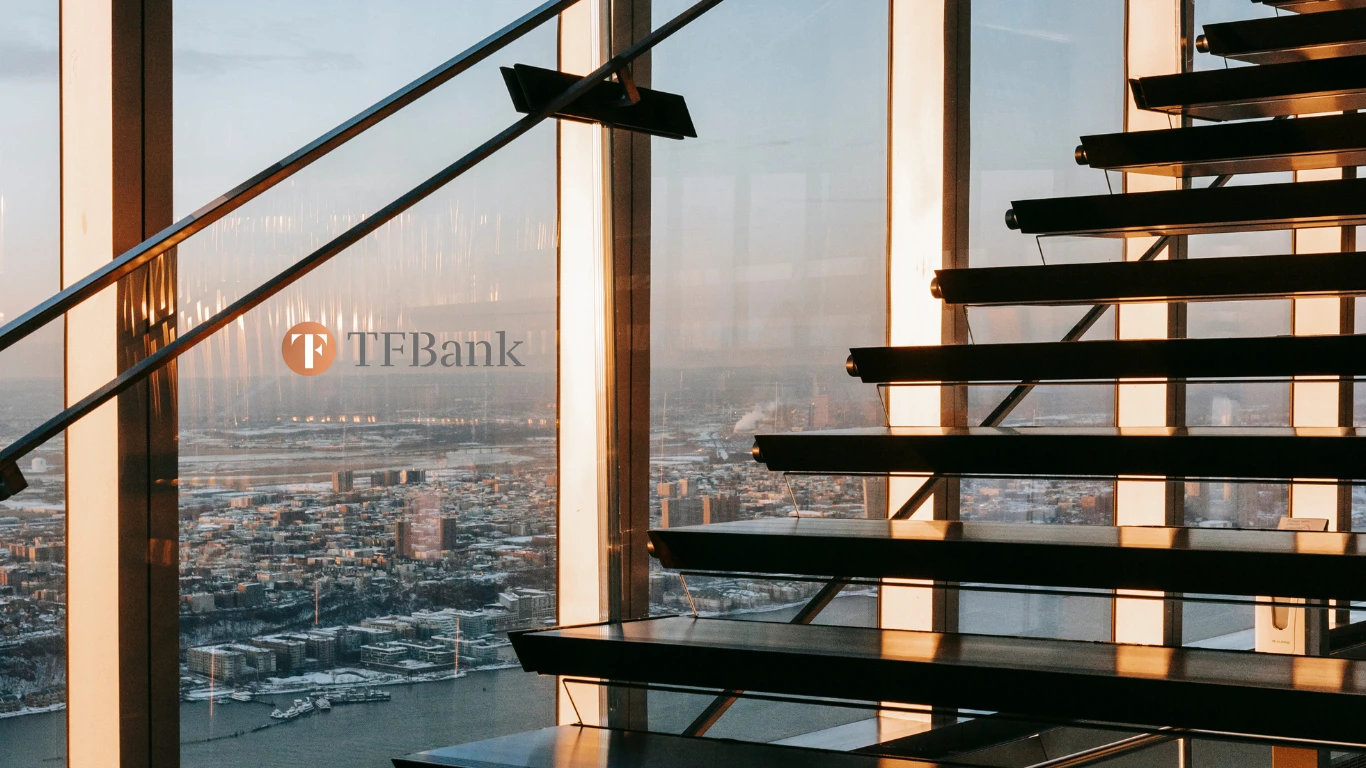 Treppe in einem Hochhaus mit Ausblick auf eine Stadt. In der Mitte ist das TF Bank Logo zu sehen,