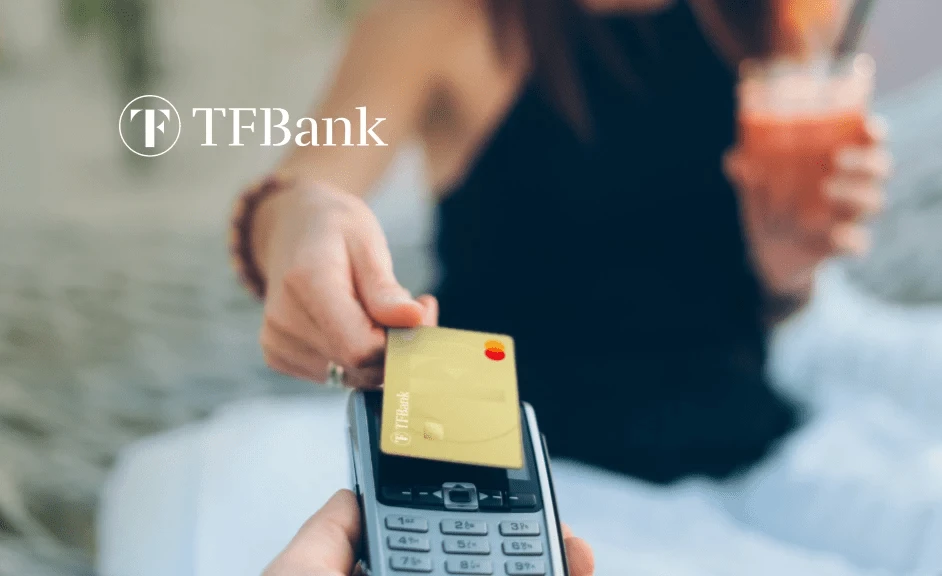 Frau zahlt kontaktlos mit der TF Mastercard Gold auf einem Kartenlesegerät.
