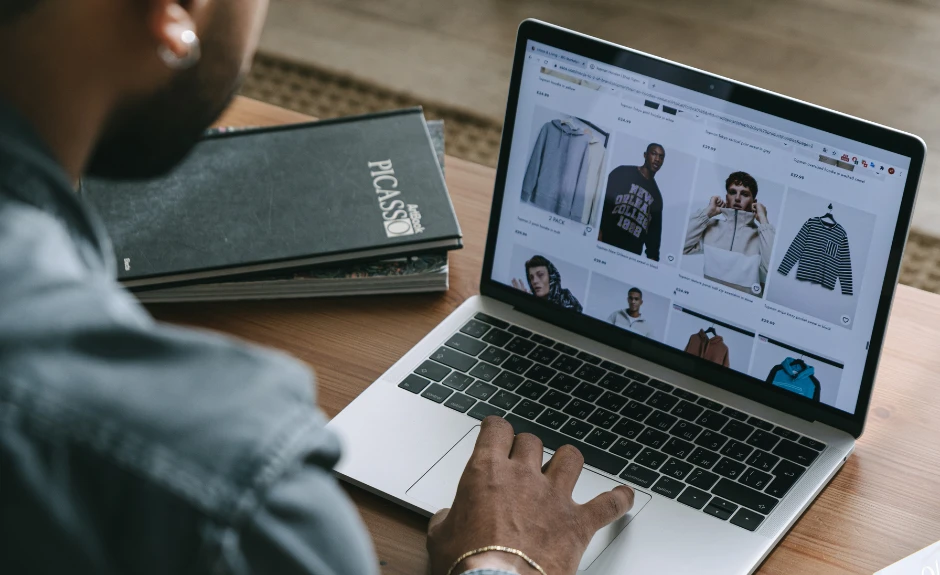 Mann sitzt am Laptop und macht Online-Shopping